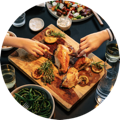 A dinner table full of healthy, home made dishes, with the family sitting and eating together