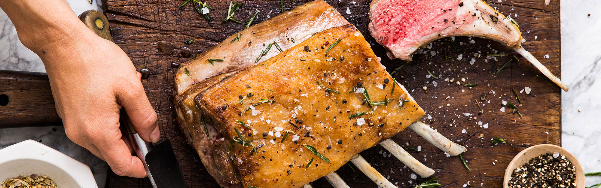 A roasted rack of lamb on a cutting board