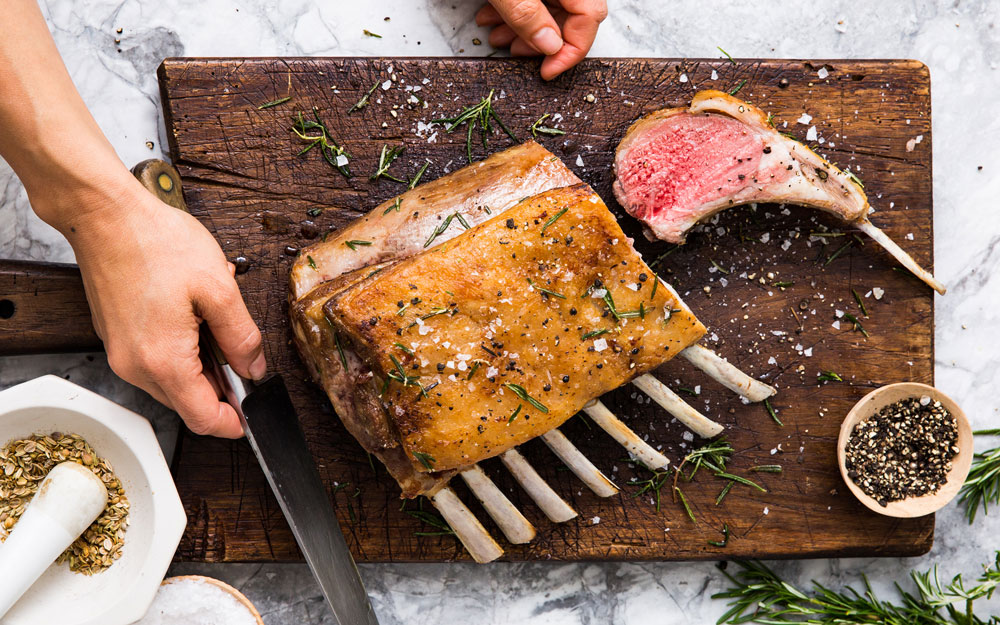 A roasted rack of lamb on a cutting board
