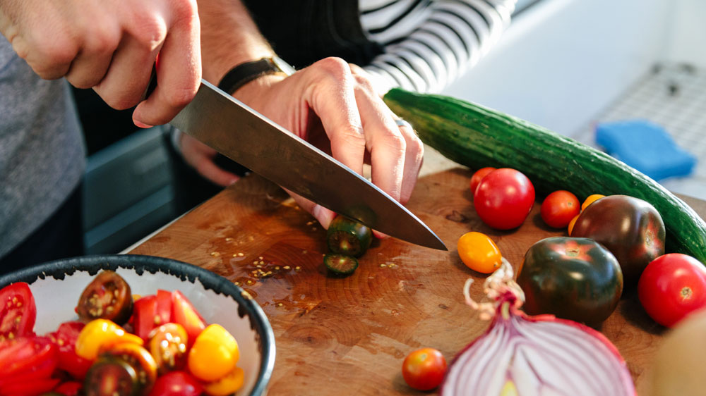 Dad and daughter preparing vegetables on a cutting board